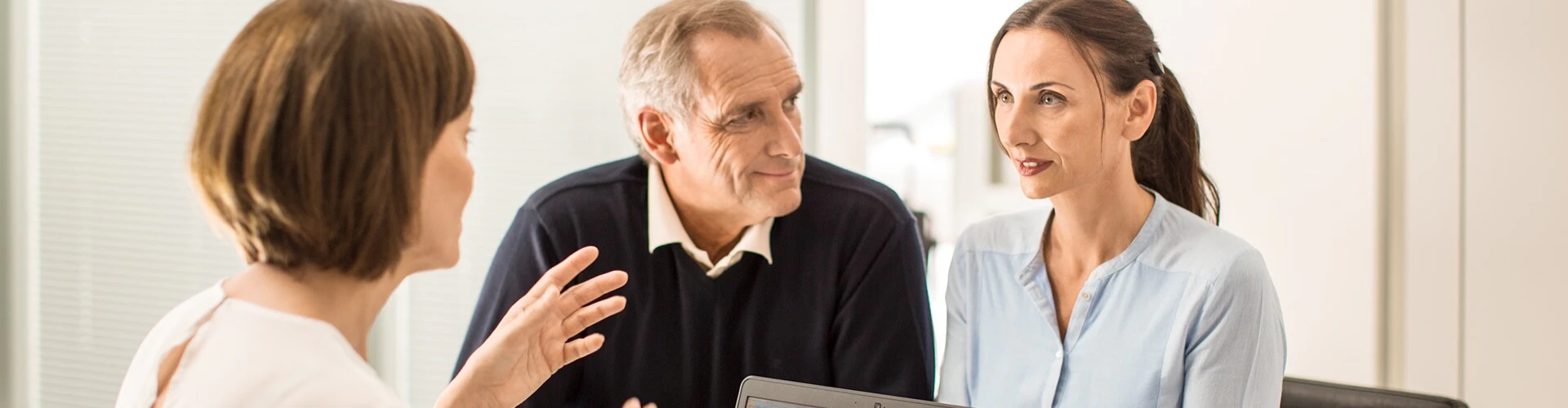 Older cochlear implant user speaking to an audiologist.