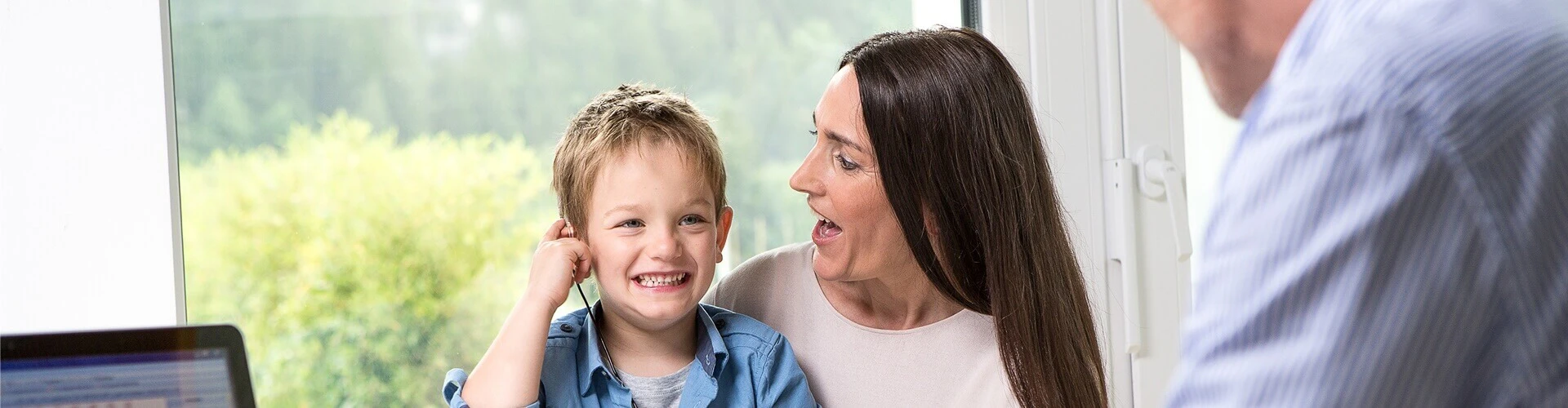 Pediatric cochlear implant user with a parent at an audiology appointment.