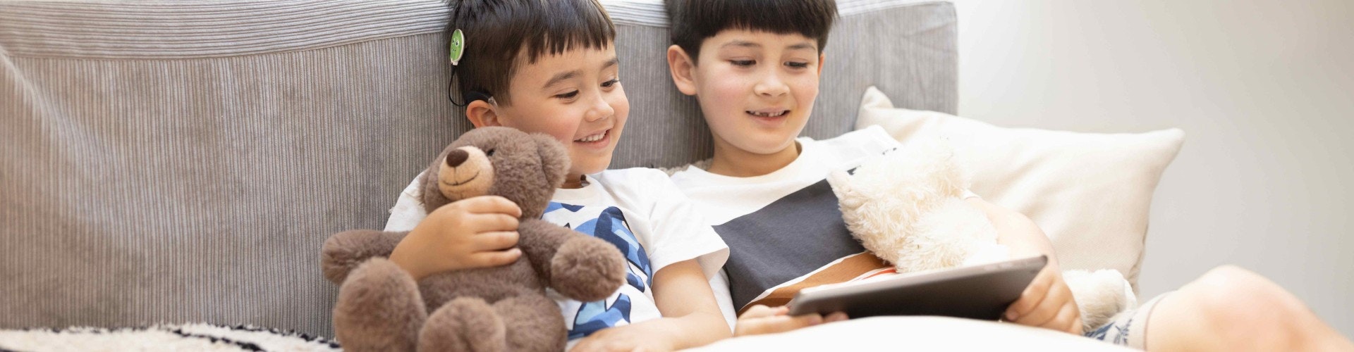 A young SONNET 3 user streaming sound directly from a tablet as he watches a video with his brother