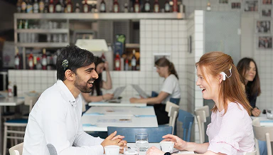 Two CI user having a conversation at a table in a restaurant