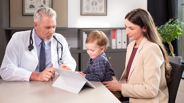 Eine Mutter sitzt mit ihrem Kind beim Arzttermin