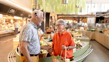 A couple of older adults shopping in a food hall
