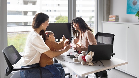 Eine Mutter sitzt mit ihrem Kind bei der Audiologin