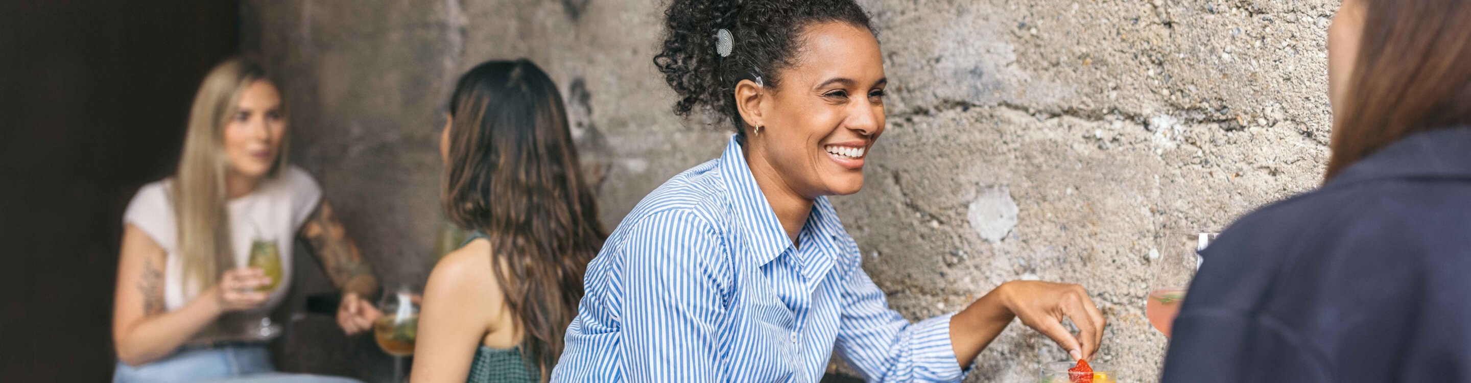 woman smiling and having a conversation while using SONNET 3 at a noisy café