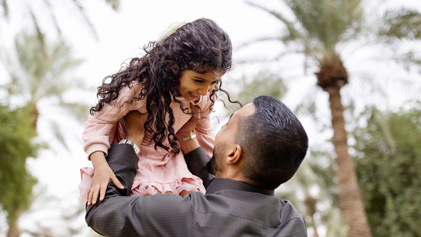 Father holding daughter up in the air.