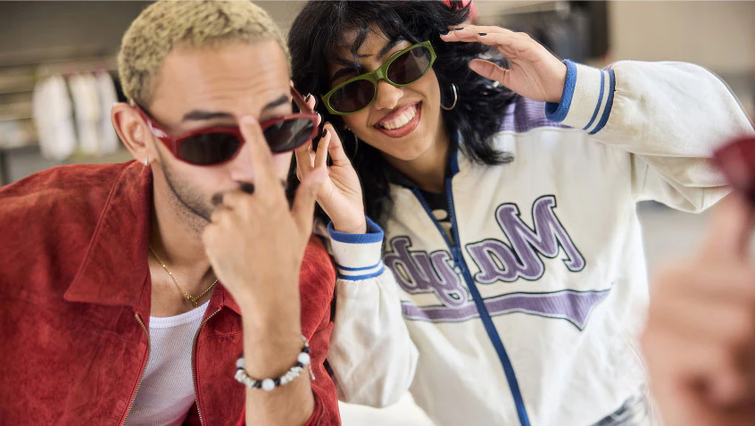 Two people trying on sunglasses.
