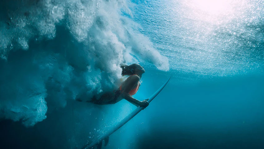 Surfer underwater after riding through a breaking wave.